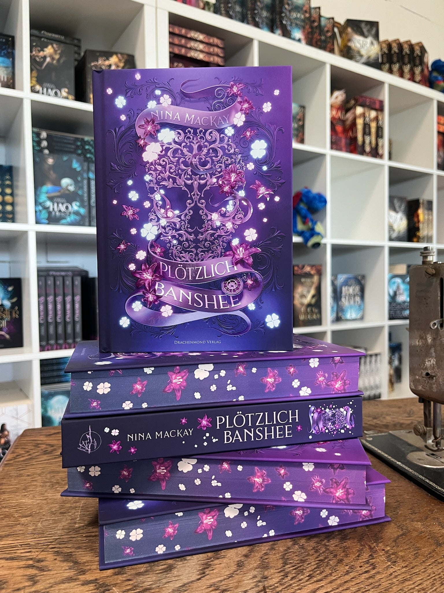 Das Cover zeigt mittig einen großen Totenkopf, der aus Verzierungen gebildet wurde. Autorin und Titel stehen auf einer Banderole, die sich unten und oben des Totenkopfes darum windet. Pinke und weiße Blüten sind überall zu sehen. Der Hintergrund des Covers ist in unterschiedlichen Violetttönen gehalten.