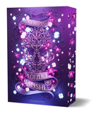 Das Cover zeigt mittig einen großen Totenkopf, der aus Verzierungen gebildet wurde. Autorin und Titel stehen auf einer Banderole, die sich unten und oben des Totenkopfes darum windet. Pinke und weiße Blüten sind überall zu sehen. Der Hintergrund des Covers ist in unterschiedlichen Violetttönen gehalten.