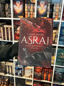 Das Bild zeigt das Buch "Asrai - Der Schatten des Shetai" von vorn. Das Cover ist dabei direkt auf den Betrachter gerichtet; es zeigt einen roten und einen schwarzen Drachen auf Rot, die um den Titel kreisen.
