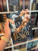 Das Produktbild zeigt das Buch "Goldmarie - Das Mädchen im Turm"- Der Titel befindet sich in goldenen Lettern in der unteren Hälfte des Covers, darüber sieht man einen langen blonden Zopf, der sich um einen Turm wickelt, der hoch in die Wolken ragt. Auf dem Farbschnitt sieht man eine Lanze, um die sich eine Haarsträhne gewickelt hat. 