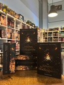 Das Bild zeigt einen Stapel von "Im Schatten der Drachenflamme". Das Cover ist dabei direkt auf den Betrachter gerichtet und der Farbschnitt sowie der Buchrücken bei den liegenden Büchern sichtbar.