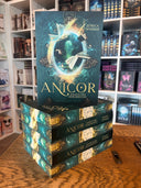 Das Bild zeigt einen Stapel von "Anicor - Jenseits der Nebelbrücken". Das Cover ist dabei direkt auf den Betrachter gerichtet und der Farbschnitt sowie der Buchrücken bei den liegenden Büchern sichtbar.
