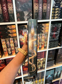 Das Produktbild zeigt das Buch "Goldmarie - Das Mädchen im Turm" von der Seite. Auf dem Farbschnitt sieht man eine Lanze, um die sich eine Haarsträhne gewickelt hat. 