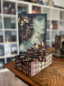 Das Bild zeigt einen Stapel von "Glutmädchen". Das Cover ist dabei direkt auf den Betrachter gerichtet und der Farbschnitt sowie der Buchrücken bei den liegenden Büchern sichtbar.