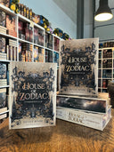 Das Bild zeigt einen Stapel von "House of Zodiac - Sternenstaub". Das Cover ist dabei direkt auf den Betrachter gerichtet und der Farbschnitt sowie der Buchrücken bei den liegenden Büchern sichtbar.