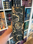 Das Bild zeigt den Farbschnitt von "Lewis van Allington und der Orden der sehenden Rose" Der Farbschnitt zeigt schwarze und goldene ineinander verflochtene Ranken. Mittig sieht man ein gezeichnetes, goldenes Auge.