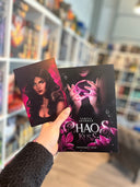 Das Bild zeigt das Buch "Chaoskuss" und die zugehörige Charakterkarte. Auf der Karte ist die Protagonistin May vor einem pinken Hintergrund abgebildet. Auf ihrer Schulter sitzt eine Fledermaus. 