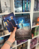 Auf dem Bild sieht man eine Hand, welche das Buch "Starlight Witch" als Hardcover mit der dazu passenden Charakterkarte hält. Auf der Charakterkarte sind die Protagonistin und der Protagonist abgebildet.