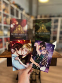 Das Bild zeigt die Charakterkarten zu "Noble Match" und "Noble Hearts". Im Hintergrund stehen die passenden Bücher dazu. 