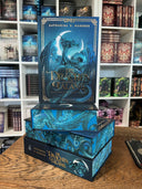 Das Cover zeigt einen blauen chinesischen Drachen mit Flügeln vor einer leuchtenden Mondsichel. Der Hintergrund ist blau gehalten. Umrandet wird das Cover von einem kupferfarbenen Rahmen. Titel und Autorinnenname sind von gleicher Farbe. Der Buchschnitt ist blau und zeigt den Drachen vom Cover.