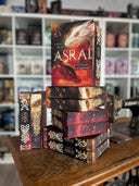 Das Bild zeigt einen Stapel von "Asrai - Die Magie der Drachen". Das Cover ist dabei direkt auf den Betrachter gerichtet und der Farbschnitt sowie der Buchrücken bei den liegenden Büchern sichtbar.