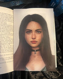 Das Page Overlay zeigt das Porträt der weiblichen Hauptfigur des Buches "Seelenverflucht". Lexi hat langes, braunes Haar. Sie trägt ein Band mit einem Anhänger um den Hals, der ein Pentagramm. 
