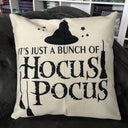 Das Produktbild zeigt ein helles Kissen mit schwarzer Aufschrift "It's just a bunch of Hocus Pocus". Verziert ist das Kissen mit einem Hexenhut, Sternen und Hexenbesen, ebenfalls in schwarz.