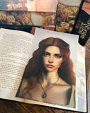 Das Page Overlay zeigt das Porträt der weiblichen Hauptfigur des Buches "Glutmädchen". Laire hat rötliches Haar, das ihr über den Rücken fällt, und Sommersprossen in Gesicht und Dekolleté. Sie trägt eine Kette mit einem Anhänger. 