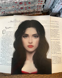 Das Page Overlay zeigt das Porträt der weiblichen Hauptfigur des Buches "Rosenrot". Rosenrot hat schwarze, offene Haare, sehr helle Haut und dunkelrote Lippen. 
