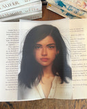 Das Page Overlay zeigt das Porträt der weiblichen Hauptfigur des Buches "Die Wellenläufer". Jolly hat schulterlanges, leicht zerzaustes dunkles Haar und trägt eine helle Bluse. 