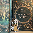 Das Produktbild zeigt ein Magnetlesezeichen mit einer langhaarigen bloden Frau in einem ockerfarbenen langen Kleid mit einem dunkelgrünem Mieder. Sie steht vor einem dunkelbraunem Pferd, mit schwarzer Mähne und sternförmiger Blässe auf der Stirn. Gezeichnet ist das Lesezeichen im Anime-Stil.