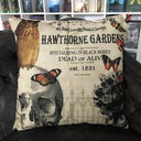 Das Produktbild zeigt ein helles Kissen mit der Aufschrift " 48, Rue Croix des Petits Champs - Hawthorne Gardens - Specializing in Black Roses - Dead or Alive - est. 1831". Auf der linken unteren Seite ist ein Totenkopf, auf dem eine braune Eule sitzt, und auf der rechten unteren Seite ein Strauß schwarz-weißer Rosen. Auf dem Kissen verteilt sind ein paar fliegende Schmetterlinge.