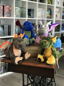 Das Bild zeigt vier Plüschdrachen in verschiedenen Farben.