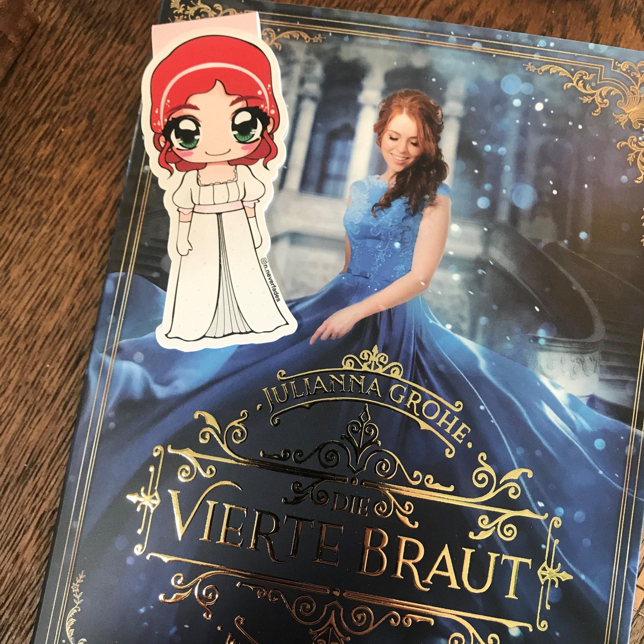 Das Produktbild zeigt ein Magnetlesezeichen mit einer rothaarigen Frau in einem langen, kurzärmeligen weißen Kleid und weißen Handschuhen. 